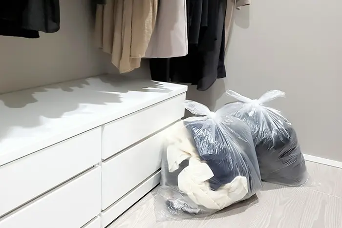 服をごみ袋に入れている