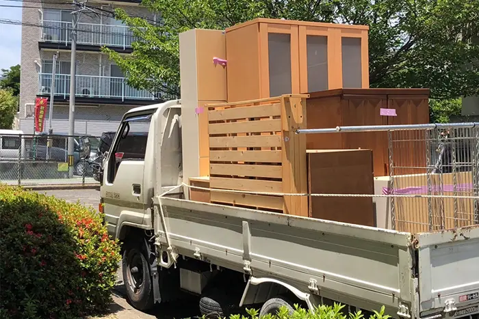 不用品回収業者が荷物をトラックに載せている