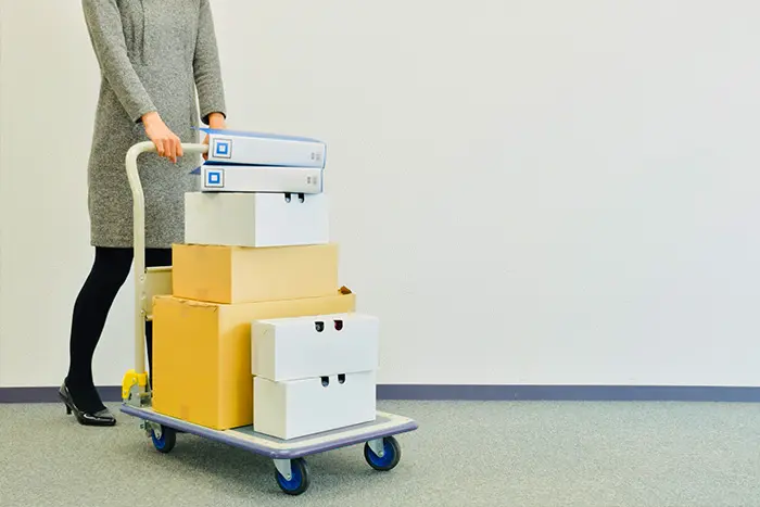 トランクルームに荷物を運ぶ女性