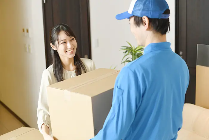 箱を集荷してもらう女性