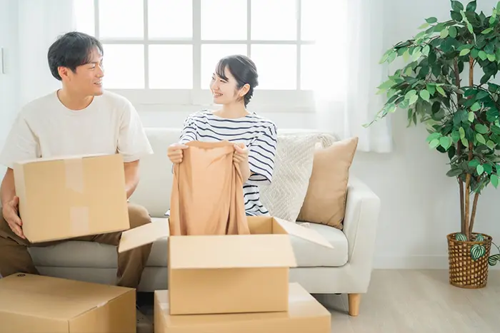 カップルが荷物を段ボールに入れている